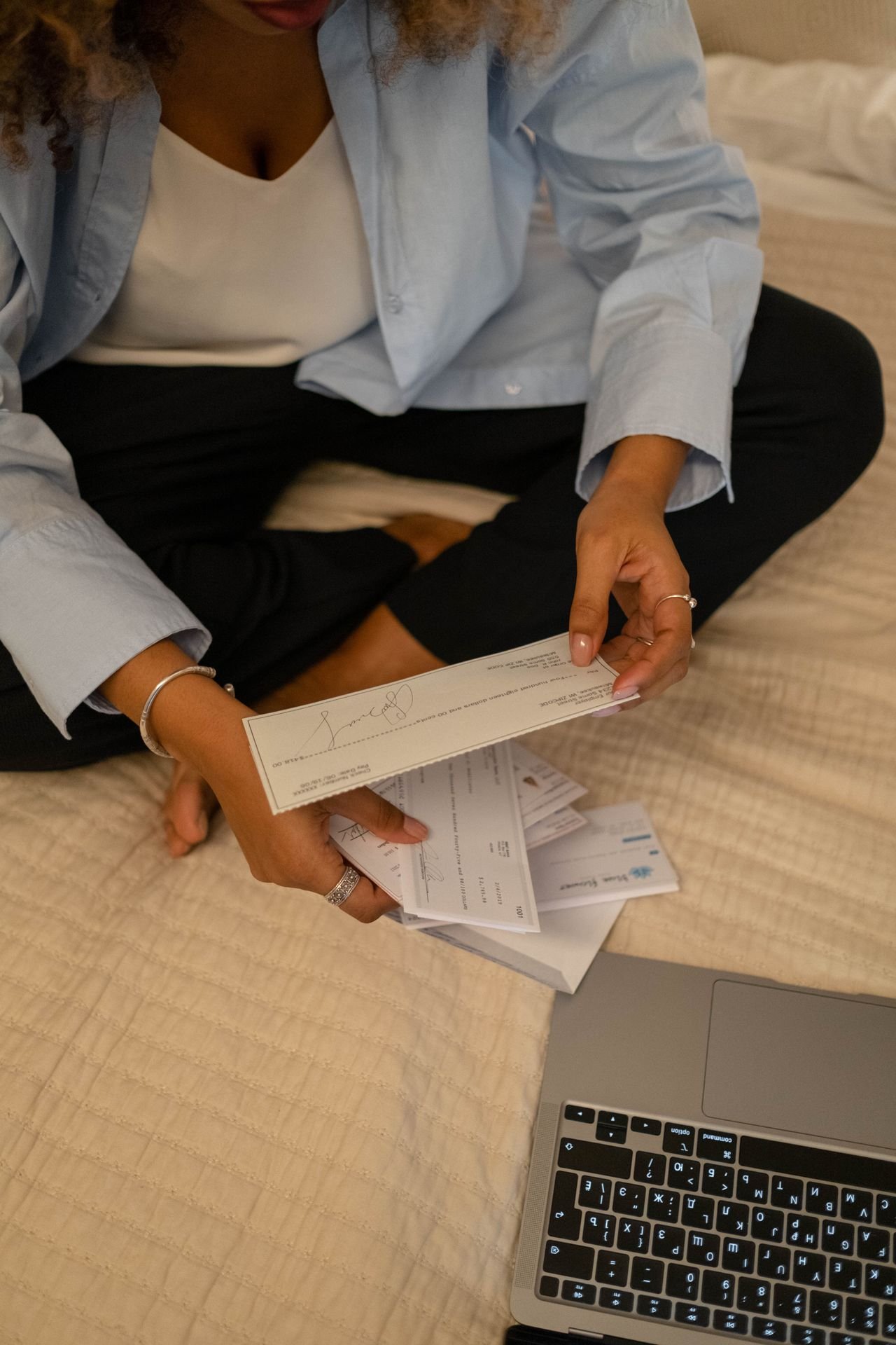Person reviewing papers beside a laptop while preparing a debt validation letter