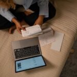 Woman reviewing her accounts on a laptop to dispute a collection on her credit report